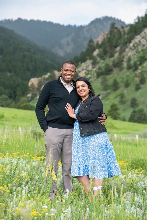 beautiful engaged couple standing in field of wildflowers